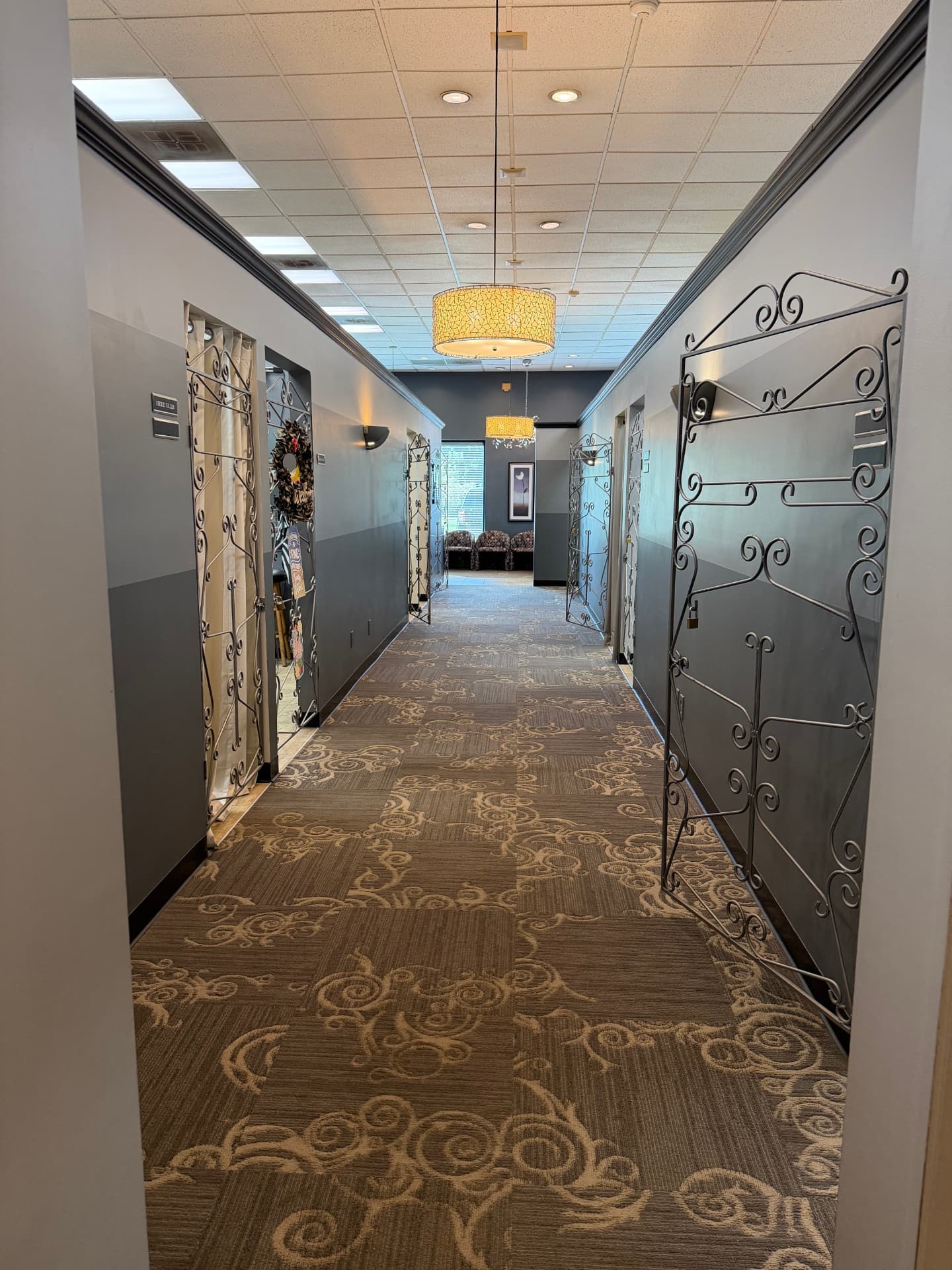 The gallery hall at Blades Hair Design, lined with wrought-iron studio doors